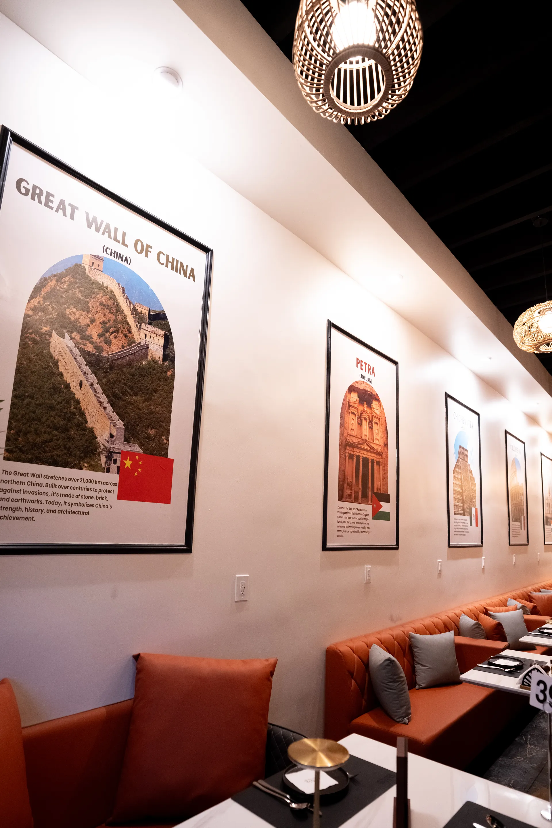DUNYA booth seating beneath framed travel posters for intimate event seating
